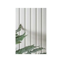 Lamele ścienne białe L0301P Largo Mardom Decor zamontowane na ścianie w salonie. Pionowe pasy optycznie podwyższają wnętrze i na